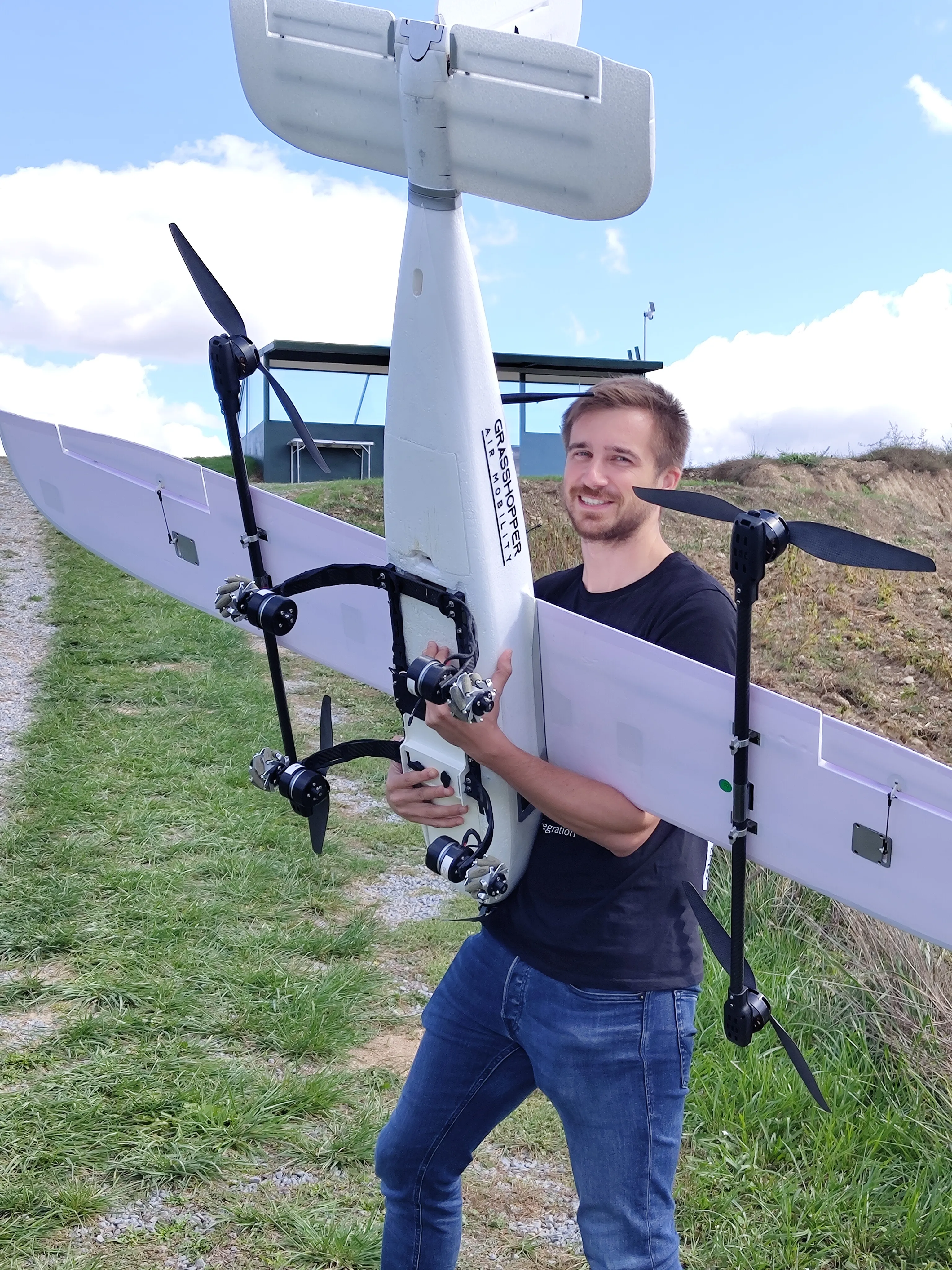 Jakob Saalfrank llevando el avión blanco de prueba de concepto de Grasshopper por la pista del BCN Drone Center, septiembre de 2025.